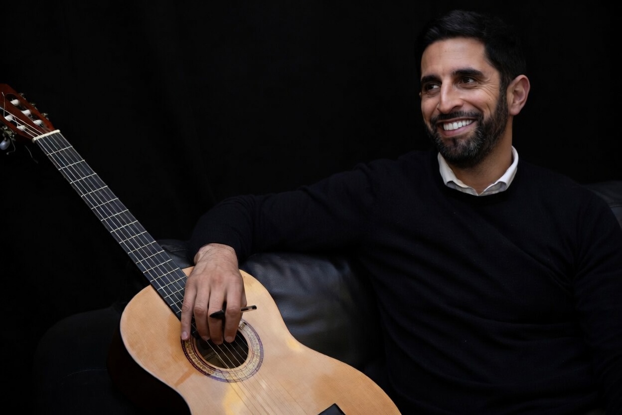 Naïm Zriouel souriant avec sa guitare
